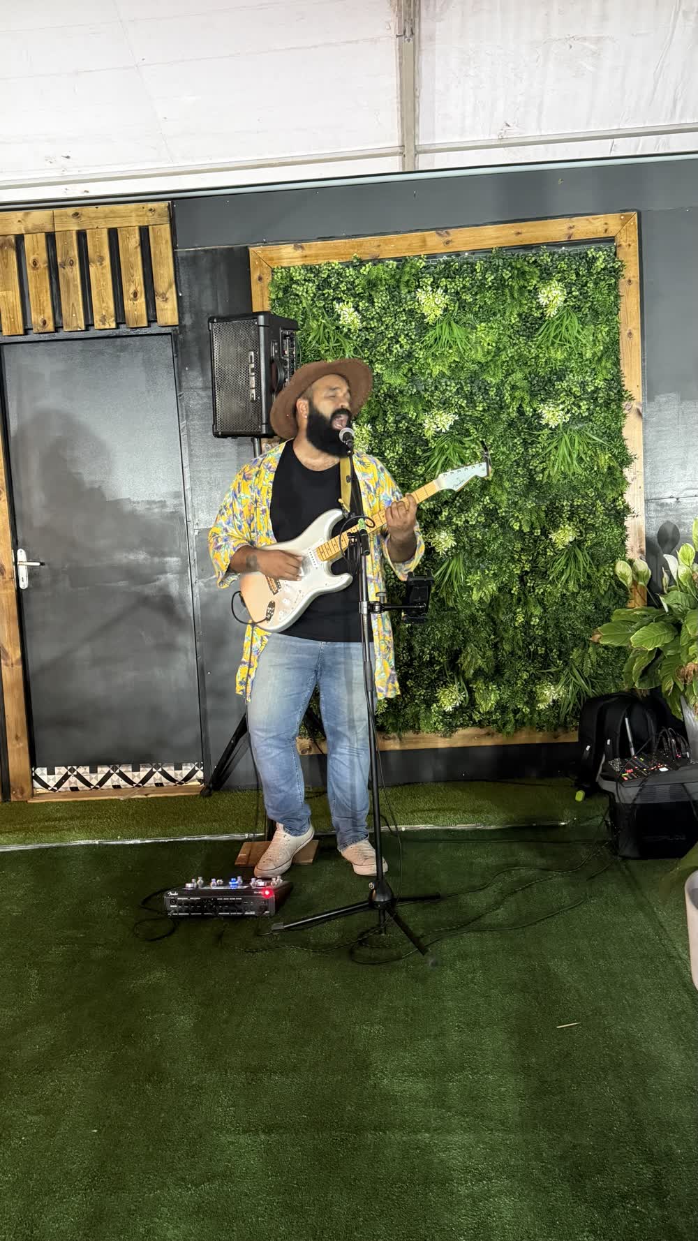 Guitariste en concert privé devant un mur végétal lors d'un événement à La Réunion