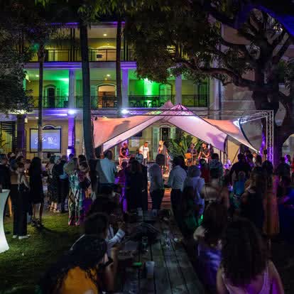 Soirée événementielle en extérieur dans un jardin avec scène sous tente et éclairages violets à La Réunion